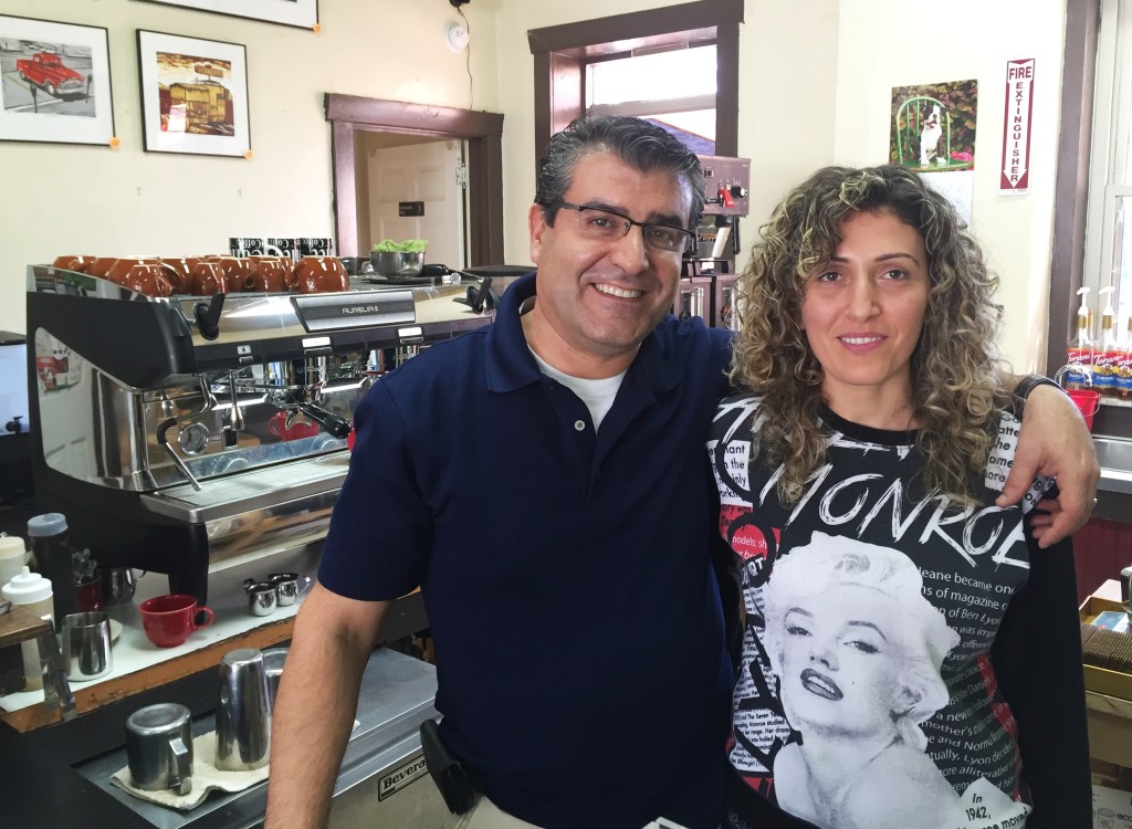  Elias Kassab, left, stands with his wife Neveen in front of a gleaming cappuccino machine. Elias is the new owner of Brookline’s former Cannon Coffee. Photo by Rebekah Devorak. 