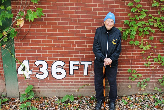 Phil Coyne stands in front of the remaining traces of Forbes Field in Oakland, a portion of the stadium’s outfield wall.